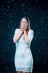 Image showing The young girl standing under running water