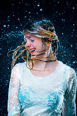 Image showing The young girl standing under running water