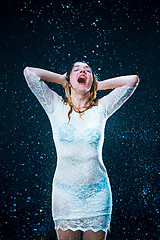 Image showing The young girl standing under running water