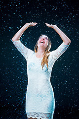 Image showing The young girl standing under running water