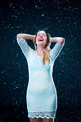 Image showing The young girl standing under running water