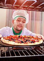 Image showing Chef cooking pizza in the oven.