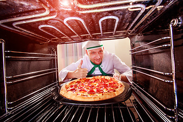 Image showing Chef cooking pizza in the oven.