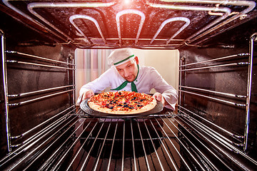 Image showing Chef cooking pizza in the oven.