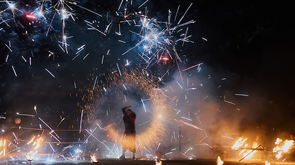 Image showing Artists juggling with burning poi\'s at fire performance.