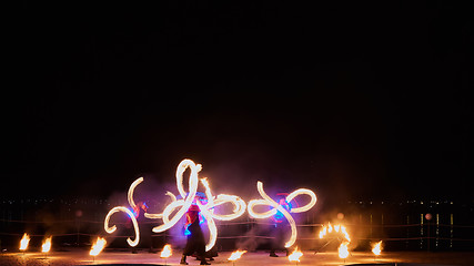 Image showing Artists juggling with burning poi\'s at fire performance.
