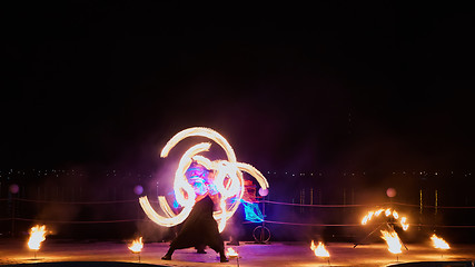 Image showing Artists juggling with burning poi\'s at fire performance.