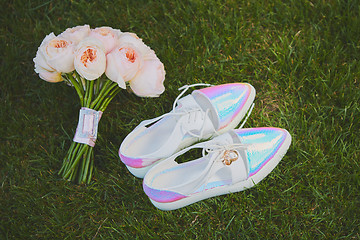 Image showing wedding bouquet and shoes lying down on green grass