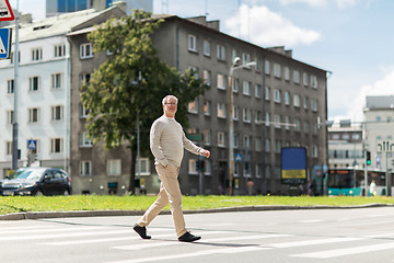 Image showing senior man walking along city crosswalk