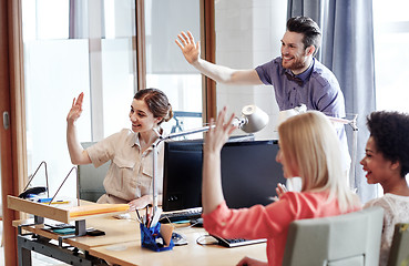 Image showing happy creative team waving hands in office