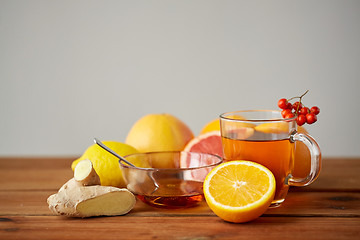 Image showing tea with honey, lemon and ginger on wood