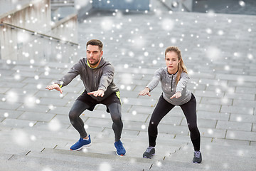 Image showing couple of sportsmen doing squats and exercising