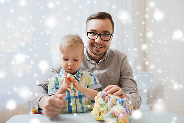 Image showing father and son playing with ball clay at home