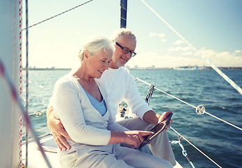 Image showing senior couple with tablet pc on sail boat or yacht