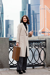 Image showing brunette with a wooden case and books in her hands