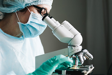 Image showing Scientist working in laboratory with microscope