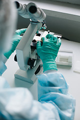 Image showing Crop hands putting microscope glasses in box