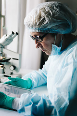 Image showing Side view of scientist working on tablet