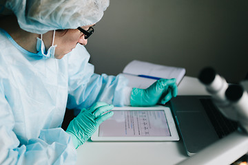 Image showing Side view of scientist working on tablet