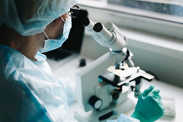 Image showing Scientist working in laboratory with microscope