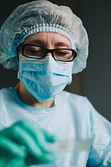 Image showing Crop hands putting microscope glasses in box