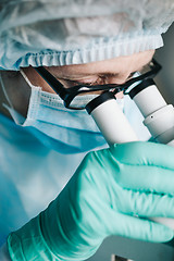 Image showing Scientist working in laboratory with microscope