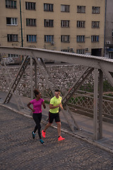 Image showing young multiethnic couple jogging in the city