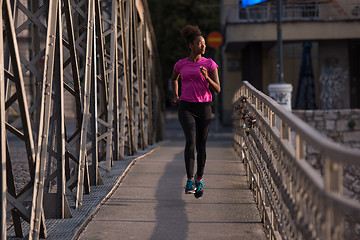 Image showing african american woman running across the bridge