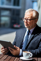 Image showing senior businessman with tablet pc drinking coffee