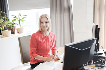 Image showing happy creative female office worker with computer