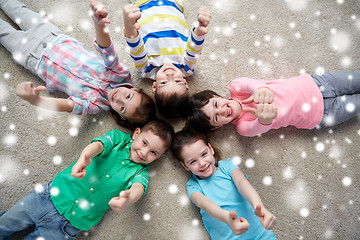 Image showing happy kids lying on floor and showing thumbs up