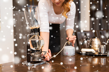 Image showing close up of woman with siphon coffee maker and pot