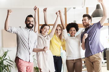 Image showing happy creative team celebrating victory in office