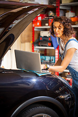 Image showing Beautiful woman mechanic near a car