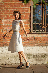 Image showing georgeous woman in white dress dancing in the street