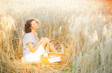 Image showing smiling woman in bright clothing among spikes in the early morni