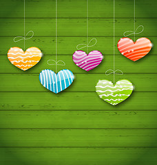 Image showing Colorful hearts hanging on green wooden texture for Valentine Da