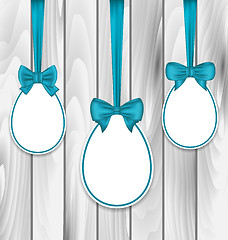 Image showing Easter paper eggs wrapping blue bows on wooden grey background