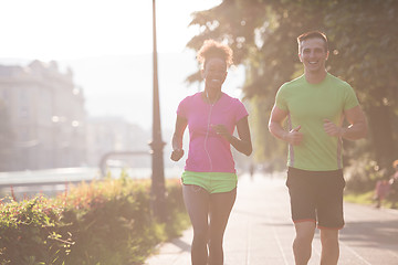 Image showing young multiethnic couple jogging in the city