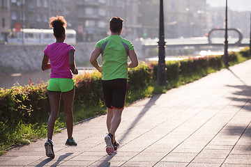 Image showing young multiethnic couple jogging in the city