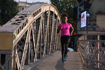 Image showing african american woman running across the bridge