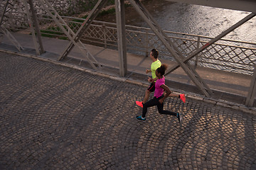 Image showing young multiethnic couple jogging in the city