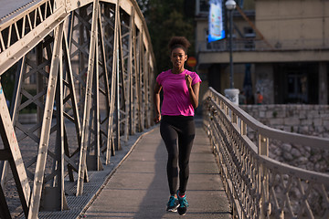 Image showing african american woman running across the bridge