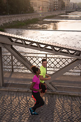 Image showing young multiethnic couple jogging in the city