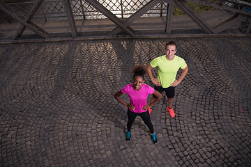 Image showing portrait of a young multiethnic couple jogging in the city