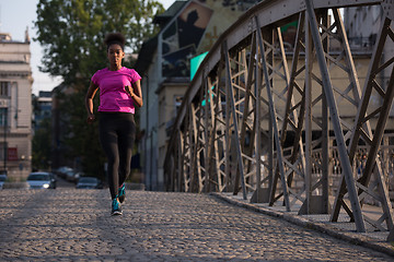 Image showing african american woman running across the bridge