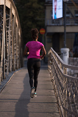 Image showing african american woman running across the bridge