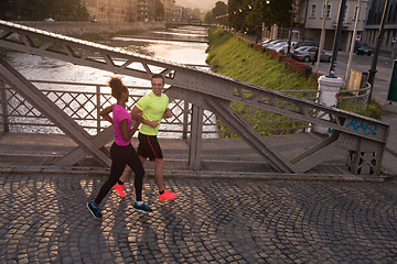 Image showing young multiethnic couple jogging in the city