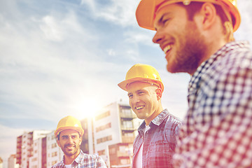 Image showing group of smiling builders in hardhats outdoors