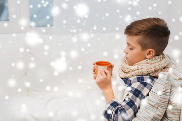 Image showing ill boy with flu in scarf drinking tea at home